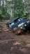 1990 Ford Bronco - This 1990 Ford Bronco navigates a challenging muddy trail through a dense forest.