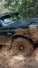 1990 Ford Bronco - This Bronco is deep in the mud, kicking up a spray as it drives through the off-road course.