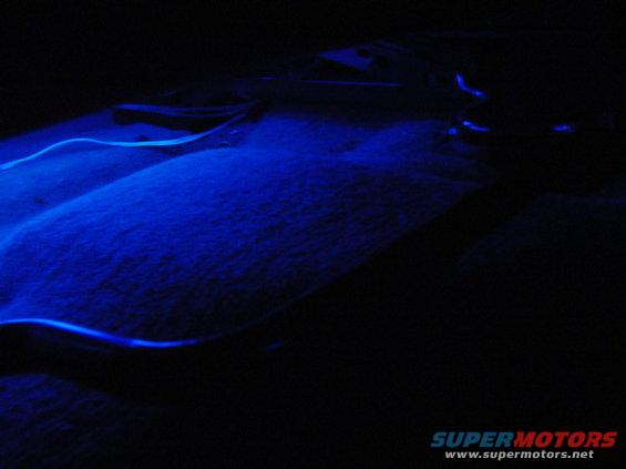 Car interior floor with blue underglow lighting and wiring