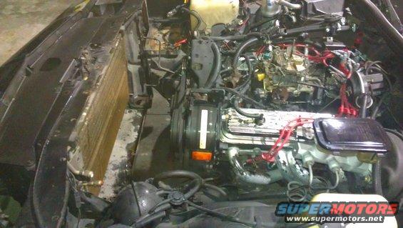 Car engine bay with radiator and engine components visible