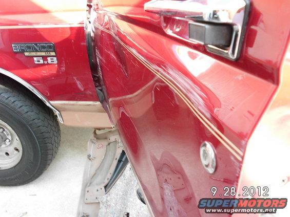 Red 1994 Ford Bronco side door with 'Bronco 5.8' badge