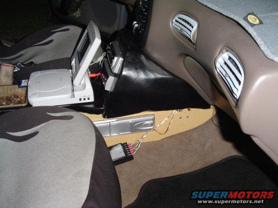 Interior view of car with screen, game console, and amplifier