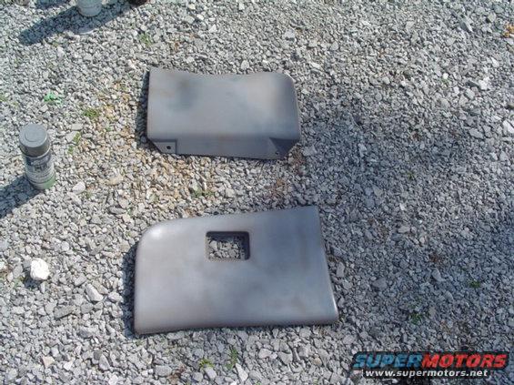 Two gray interior trim pieces and a spray can on gravel