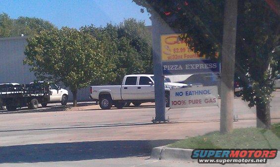 White pickup truck parked next to a Pizza Express sign