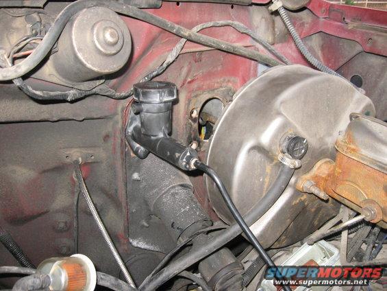 I needed to move the brake booster out of the way to get the drill in.  A circular metal saw drill bit worked perfectly and cut right through the firewall.