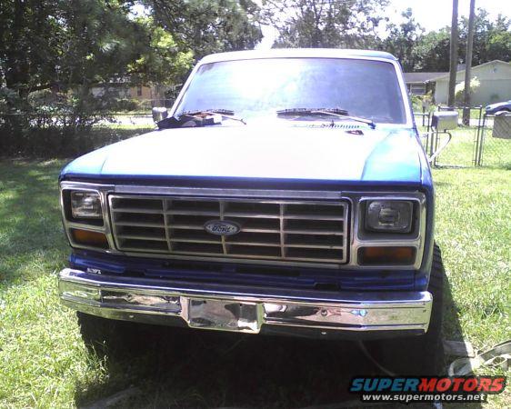 Blue Ford truck front end with chrome grille and bumper