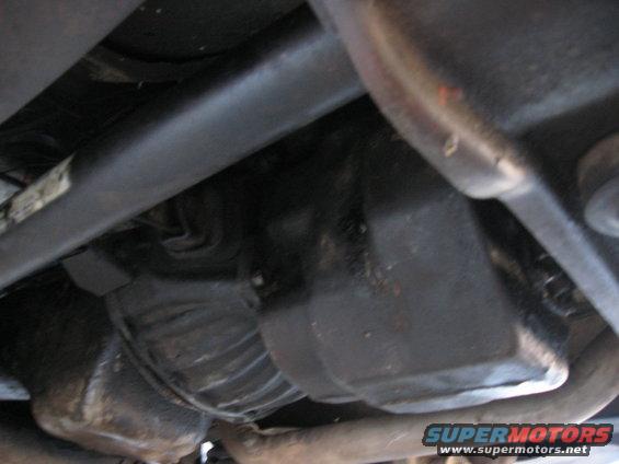 Underside view of vehicle drivetrain components, including a driveshaft and transmission housing