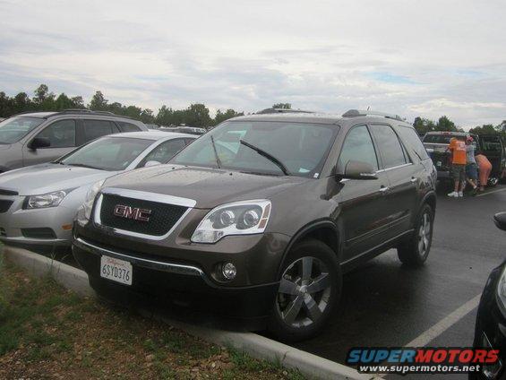 Brown GMC Acadia parked curbside, front 3/4 view. License plate 6SYD376