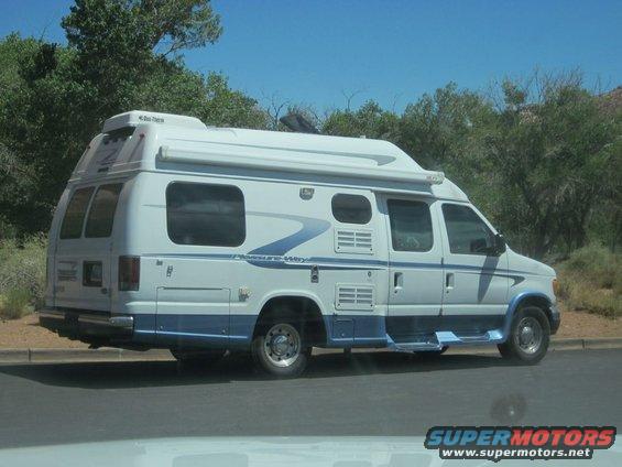 White and blue camper van, side view, with 'Leisure Way' decal