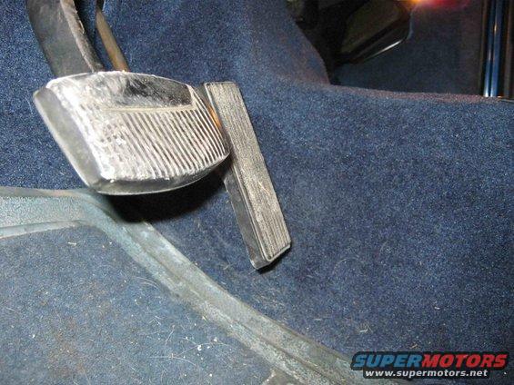 Close-up of car's brake and gas pedals on blue carpet