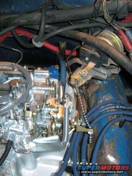 Engine carburetor with blue spark plug wires and red electrical cables