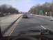 2003 Ford Crown Victoria - A dark sedan is seen from the perspective of another vehicle on a highway with trees lining the sides.
