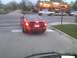 2003 Ford Crown Victoria - Red sedan waits at a crosswalk near a restaurant, with traffic in the background.