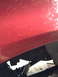 1996 Ford F-150 - Close-up view of a red truck's undercarriage, revealing suspension components and a shock absorber.