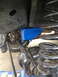1996 Ford F-150 - Close-up of a blue suspension bracket installed on a vehicle's axle, part of a solid axle swap.