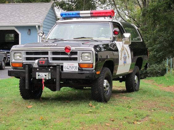 1987 Dodge Ramcharger police SUV, front view, black and white with light bar and winch