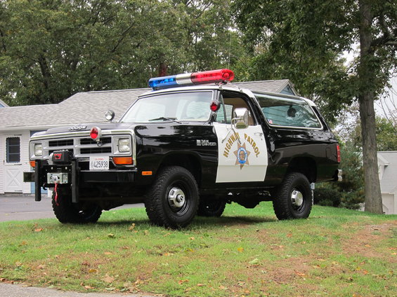 Black and white 1987 Dodge Ramcharger police vehicle with light bar and winch