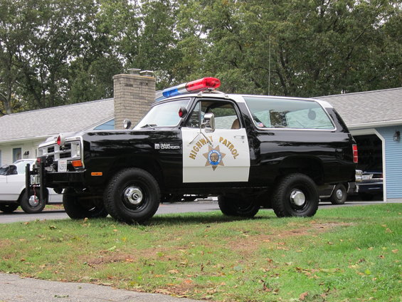 Black and white Dodge Ramcharger with "HIGHWAY PATROL" on door, parked on grass
