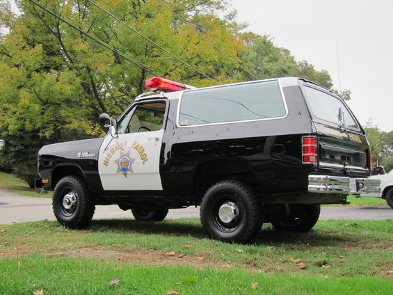 1987 Dodge Ramcharger Highway Patrol SUV, side view. Black and white paint with light bar on roof