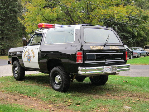 Rear view of a black and white 1987 Dodge Ramcharger highway patrol SUV with "HIGHWAY PATROL" text