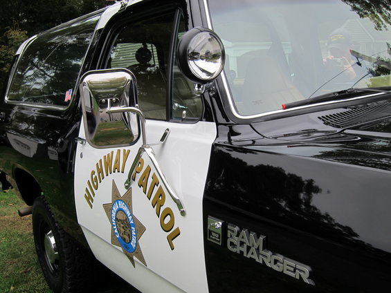 Side view of a black and white California Highway Patrol Ramcharger with "HIGHWAY PATROL" on the door