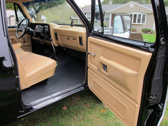 Interior of a 1987 Dodge 1500 pickup truck, showing tan seats and door panels