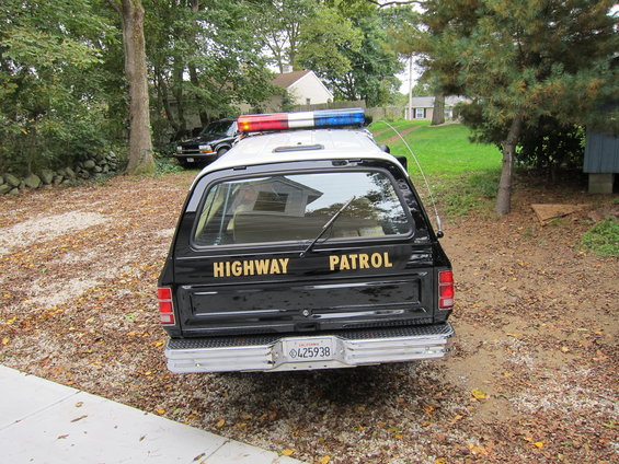 Rear view of a 1987 Dodge 1500 highway patrol truck with light bar