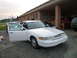 1997 Ford Crown Victoria - White 1997 Ford Crown Victoria parked outside a building with both front doors ajar.