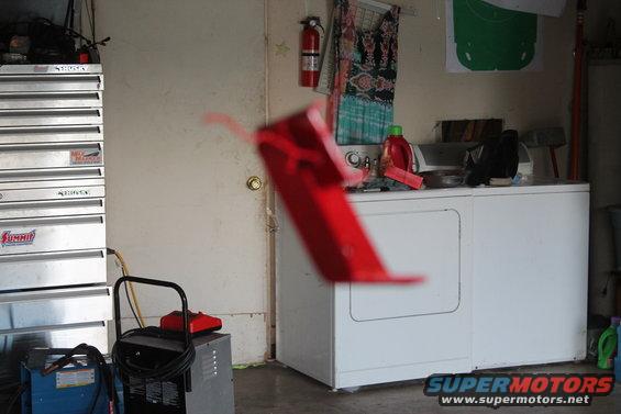 red plastic part in front of washer and dryer