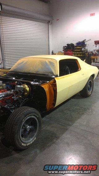 1973 Chevrolet Camaro in a garage, front end disassembled, yellow primer paint