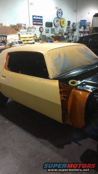 1973 Chevrolet Camaro body in a workshop, partially painted and masked