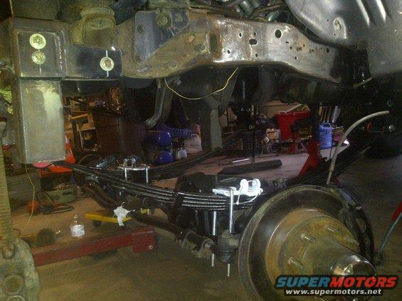 Undercarriage view of vehicle suspension with leaf springs and brake assembly