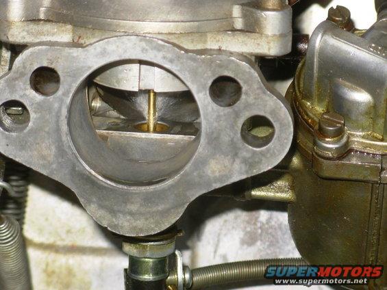 Close-up of a carburetor's intake with a brass needle visible inside