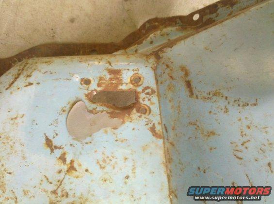 Rusted light blue metal part with visible bolt holes and SuperMotors logo