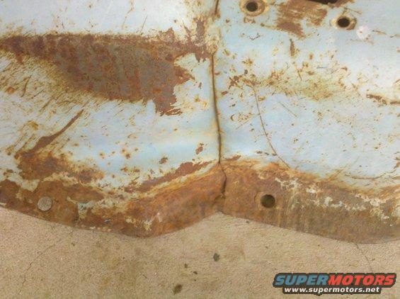 close-up of rusted metal panel with visible seam and bolt holes