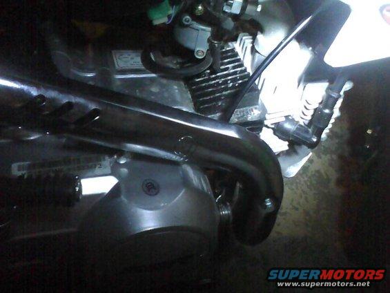Close-up of a motorcycle engine's exhaust pipe and cylinder fins
