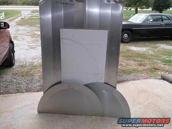 Sheet metal parts laid out in front of a black 1971 Ford sedan