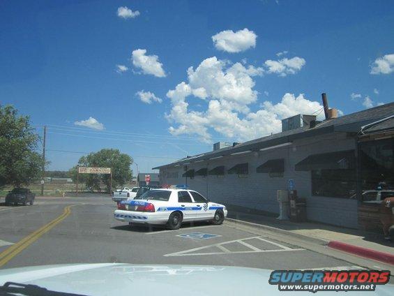 1991 Ford Crown Victoria police car parked, 'MURPHY PATROL' on rear door. Another car visible in distance