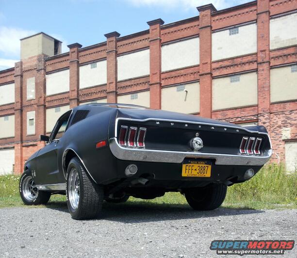 1968 Ford Mustang rear view with matte black paint and yellow New York license plate FFF-3887