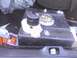 2003 Ford Crown Victoria - A fuel tank and pump assembly are stored in the trunk of a vehicle, alongside other items.