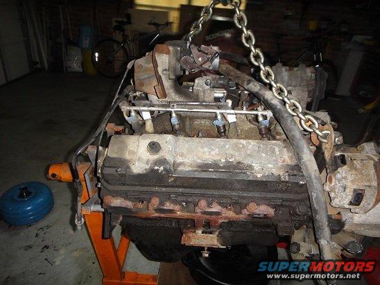 Engine on an orange stand, suspended by chains