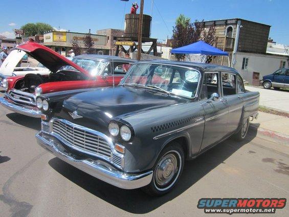 Checker Marathon taxi with hood open on red car behind it