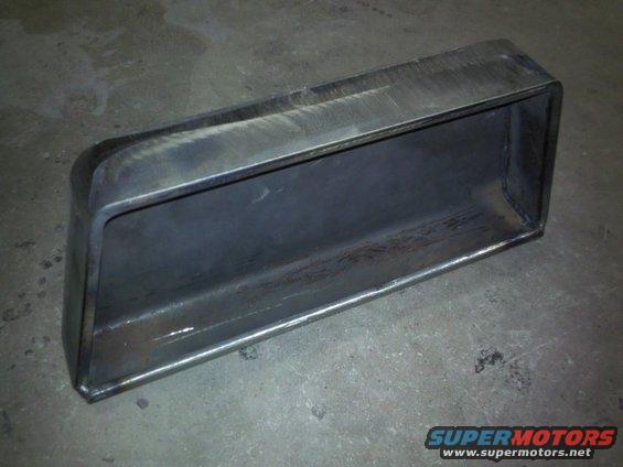 Rectangular metal intake pipe with rounded corners, sitting on a concrete floor