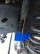 1996 Ford F-150 - A blue suspension block is installed near the coil spring on a vehicle's frame.