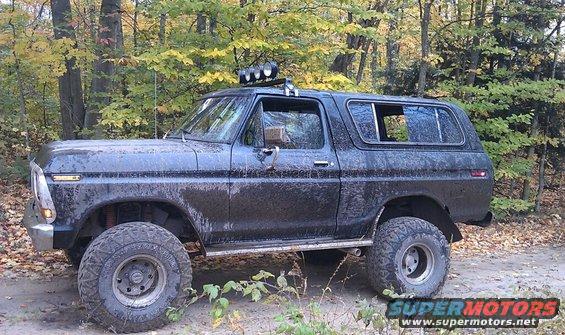 Black Ford Bronco with off-road tires and roof lights, side view