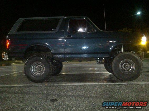 Dark blue lifted Ford Bronco parked at night