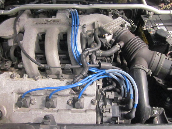 Engine bay of a 1993 Mazda MX-3 showing V6 DOHC 24-valve engine with blue spark plug wires