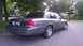 2003 Ford Crown Victoria - This Ford Crown Victoria is seen from the rear quarter angle, parked on a paved road with trees lining the background.