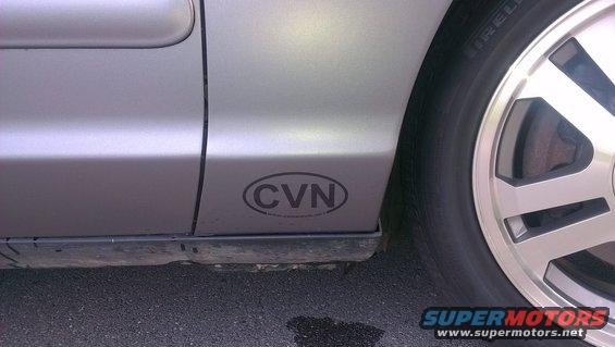 Silver 2003 Ford Crown Victoria side view with CVN emblem on lower door