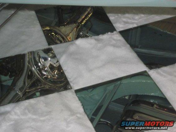 Car interior with reflective chrome trim and white padding, viewed from above